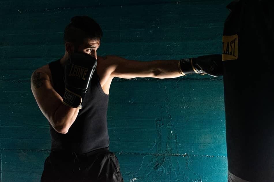 photo of man punching boxing bag